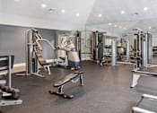 Thumbnail 15 of 24 - A spacious gym with a variety of equipment including a treadmill, weight bench, and leg press machine at Ridge Crossings Apartments, Alabama