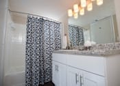 Thumbnail 23 of 24 - A bathroom with a shower curtain and a counter at Ridge Crossings Apartments, Hoover