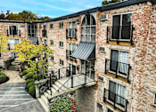 Thumbnail 17 of 18 - A brick building with balconies and a black metal railing.