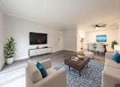 Thumbnail 7 of 18 - A living room with a large couch, a coffee table, and a flat-screen TV.