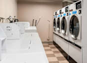 Thumbnail 13 of 18 - A row of JETZ washing machines are lined up in a laundromat.