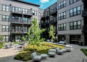 Thumbnail 2 of 58 - A modern building with a courtyard and seating area.