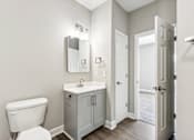 Thumbnail 2 of 14 - A white toilet sits next to a sink in a bathroom.