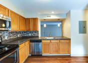 Thumbnail 4 of 20 - an empty kitchen with wooden cabinets and granite counter tops