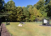 Thumbnail 29 of 49 - a fenced in area with a picnic table and a bench  at Peaks at Gainesville, Gainesville, GA, 30507