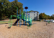 Thumbnail 27 of 49 - a playground at a park with a building in the background  at Peaks at Gainesville, Gainesville, 30507