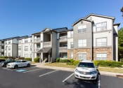 Thumbnail 7 of 49 - an apartment building with cars parked in front of it  at Peaks at Gainesville, Gainesville, GA