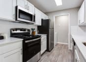 Thumbnail 36 of 49 - a kitchen with black appliances and white cabinets  at Peaks at Gainesville, Gainesville, GA, 30507