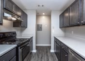 Thumbnail 19 of 27 - an empty kitchen with stainless steel appliances and dark wood cabinets