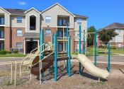 Thumbnail 15 of 27 - an empty playground in front of an apartment building