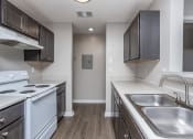 Thumbnail 14 of 27 - the preserve at ballantyne commons apartment kitchen with white appliances and dark cabinets