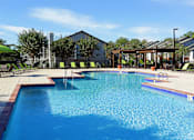 Thumbnail 8 of 24 - A large swimming pool with a sunny sky in the background.