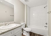 Thumbnail 7 of 20 - A white bathroom with a sink, toilet, and bathtub.