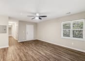 Thumbnail 4 of 20 - A room with a ceiling fan and a window with a view of trees.