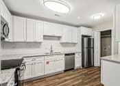 Thumbnail 5 of 20 - A kitchen with white cabinets and a black counter top.