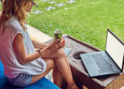 Thumbnail 24 of 27 - a woman sitting on a bench with a laptop and a cup of coffee