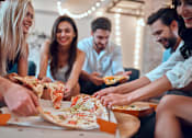 Thumbnail 23 of 27 - a group of people eating pizza at a party