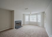 Thumbnail 19 of 21 - an empty living room with a fireplace and a window