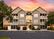 Thumbnail 31 of 31 - A large apartment building with a parking lot in front.