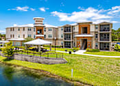 Thumbnail 28 of 34 - a large apartment building with a river in front of it at Turtle Creek, Florida