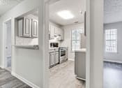 Thumbnail 15 of 60 - Kitchen And Hallway at Wildcreek Apartments, Clarkston, GA
