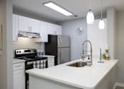 Thumbnail 14 of 40 - A kitchen with a black refrigerator and white cabinets.