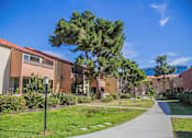 Thumbnail 13 of 18 - a sidewalk in front of a building with trees and grass