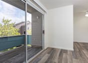 Thumbnail 17 of 26 - an empty living room with a sliding glass door to a balcony