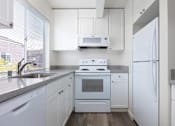 Thumbnail 19 of 26 - a kitchen with white appliances and white cabinets