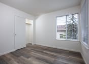 Thumbnail 20 of 26 - a bedroom with a large window and wood floors