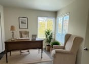 Thumbnail 25 of 26 - A room with a desk, chair, and potted plant.
