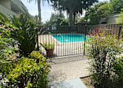 Thumbnail 11 of 15 - a pool in a backyard with a black fence