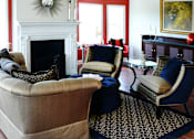 Thumbnail 35 of 39 - Living room area of an apartment, fitted with a fireplace, sofa, lounge chairs, and high ceiling.