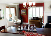 Thumbnail 38 of 39 - Living room area of an apartment, fitted with wood flooring, a fireplace, high ceiling, and lounge chairs.