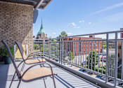 Thumbnail 21 of 39 - Balcony area of an apartment at Park Lane Villas, fitted with lounge chairs and iron railing.