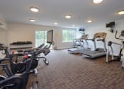 Thumbnail 4 of 15 - a room filled with cardio equipment and a flat screen tv