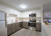Thumbnail 4 of 8 - a kitchen with white cabinets and stainless steel appliances