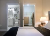 Thumbnail 5 of 8 - a bedroom with a large bed and a bathroom in the background
