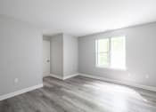 Thumbnail 25 of 30 - A room with a wooden floor and a window letting in sunlight.