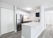 Thumbnail 5 of 30 - A modern kitchen with white cabinets and a stainless steel refrigerator.