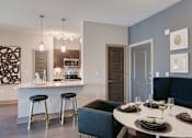 Thumbnail 4 of 28 - Modern kitchen with a bar area and a dining table at Caldwell, Houston