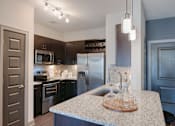 Thumbnail 2 of 28 - Kitchen with a granite countertop and stainless steel appliances at Caldwell, Houston