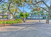Thumbnail 32 of 38 - a courtyard with trees and a fence in front of a building at The Beck at Hidden River, Florida