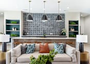 Thumbnail 14 of 43 - A modern living room with a grey couch and a grey tiled backsplash.