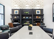 Thumbnail 22 of 43 - A conference room with a long table, chairs, and a bookshelf with decorative items.