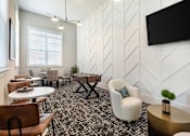 Thumbnail 23 of 43 - A modern lounge area with a patterned carpet and white walls.