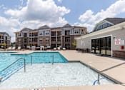 Thumbnail 42 of 43 - A large swimming pool in front of apartment buildings.