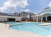 Thumbnail 41 of 43 - A swimming pool in front of a building with a glass wall.