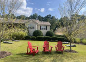 Thumbnail 39 of 40 - three red chairs sitting in a lawn in front of a house at Addison on Cobblestone, Georgia