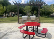 Thumbnail 40 of 40 - a picnic table and chairs in front of a grill at Addison on Cobblestone, Georgia